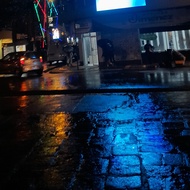 Photo of a stone park floor reflecting the streetlights
